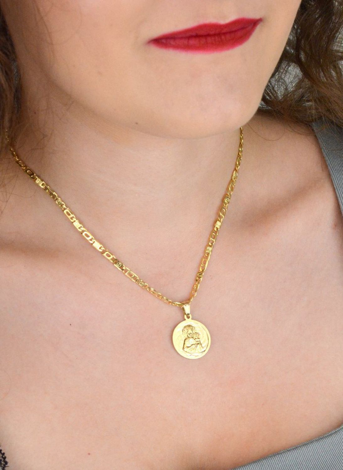 Złota zawieszka próby 585 z wizerunkiem Matki Boskiej z Dzieciątkiem. Wymiary 2 cm, waga 2,63 g. Klasyczny medalik religijny w eleganckiej formie.1.jpg